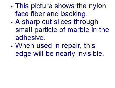Text Box: This picture shows the nylon face fiber and backing.
A sharp cut slices through small particle of marble in the adhesive.
When used in repair, this edge will be nearly invisible.
